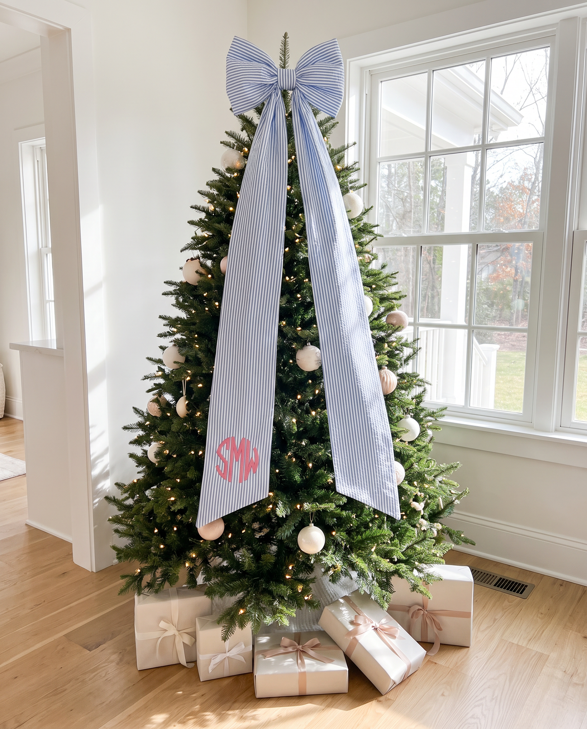 Striped blue bow sash tied to the top of a Christmas tree
