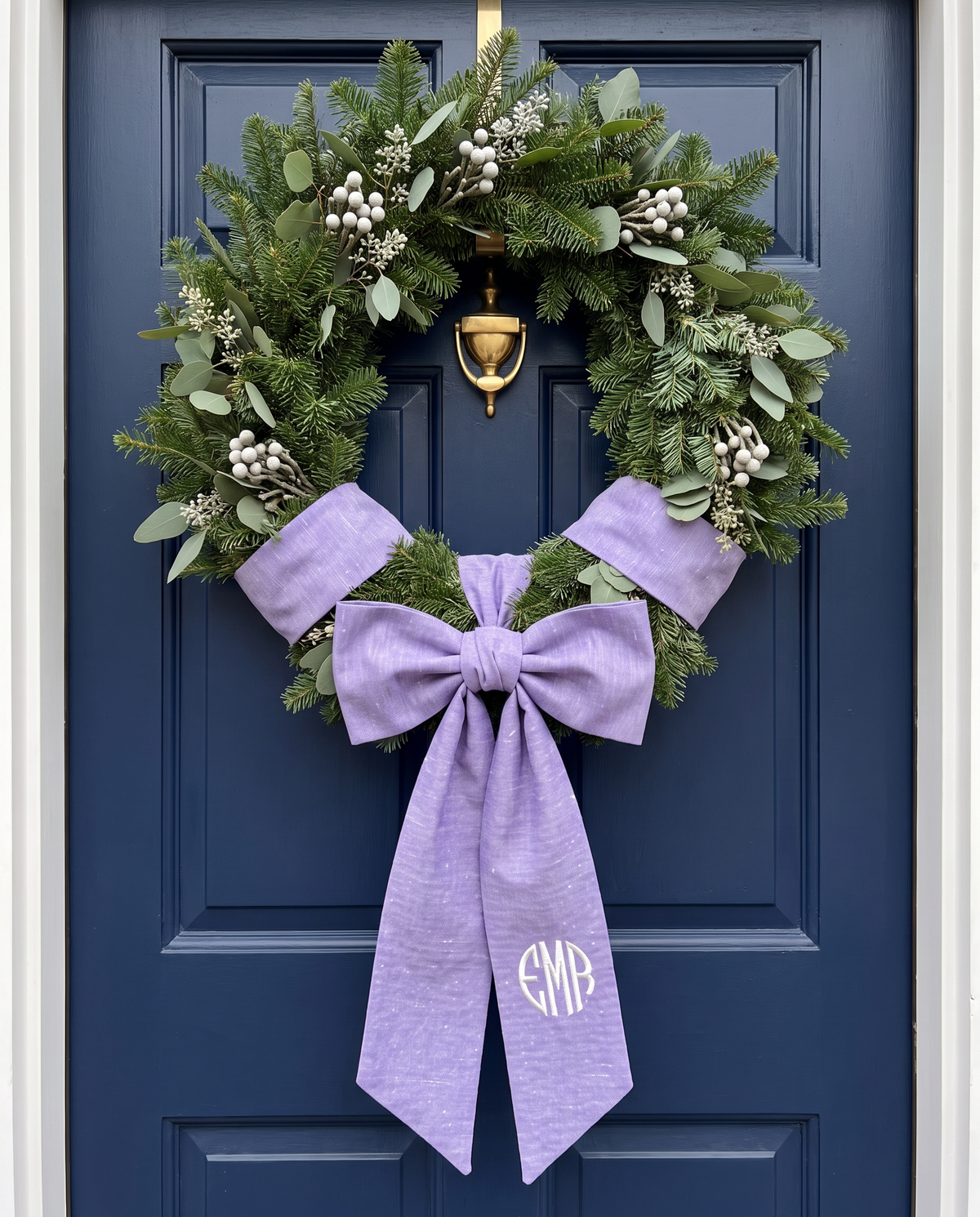 Lavender bow sash on a navy wooden door wreath