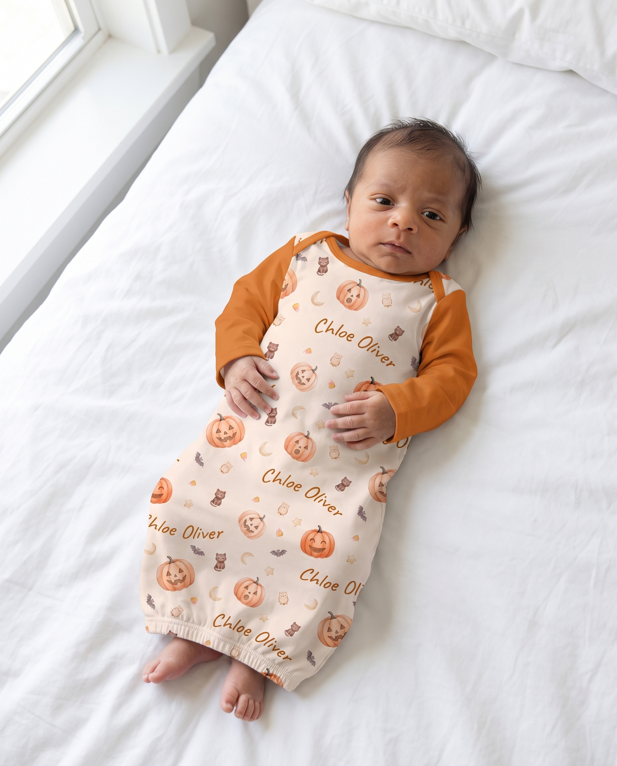 Baby in the personalized sleep gown in Golden Jack pumpkin print, full length view