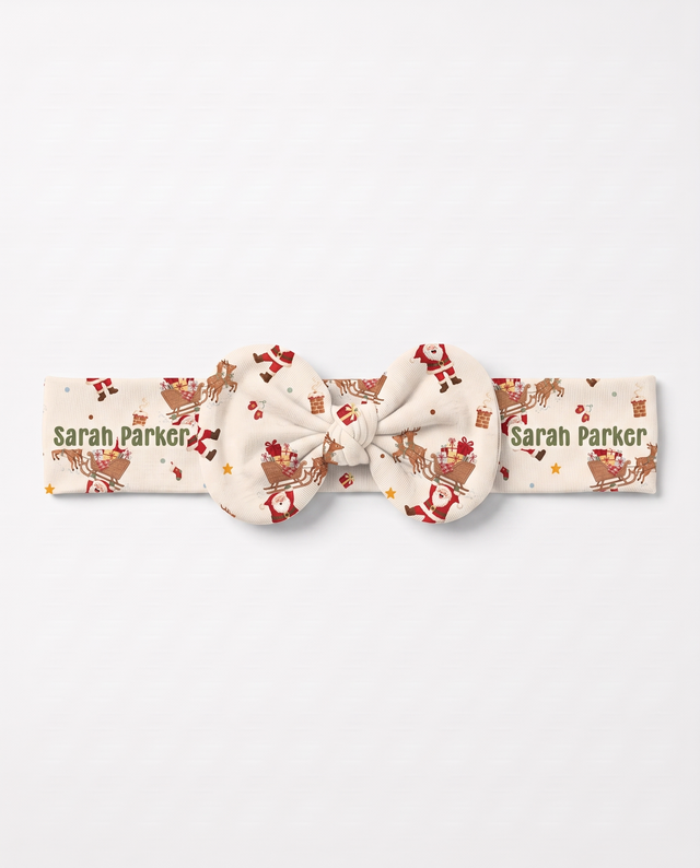 Personalized Santa's Joyride bow headband with the baby's name, on white