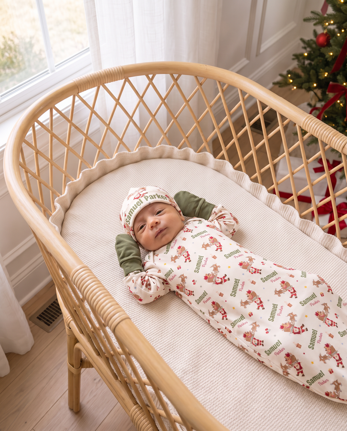 Baby in the Santa's Joyride sleep gown, mittens and beanie in a rattan bassinet