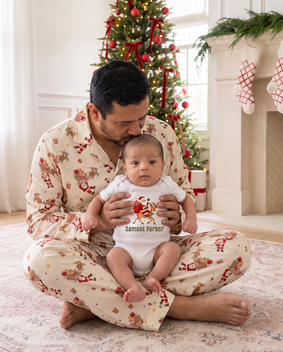 Dad in Santa's Joyride pajamas holding his baby in the personalized Santa graphic bodysuit
