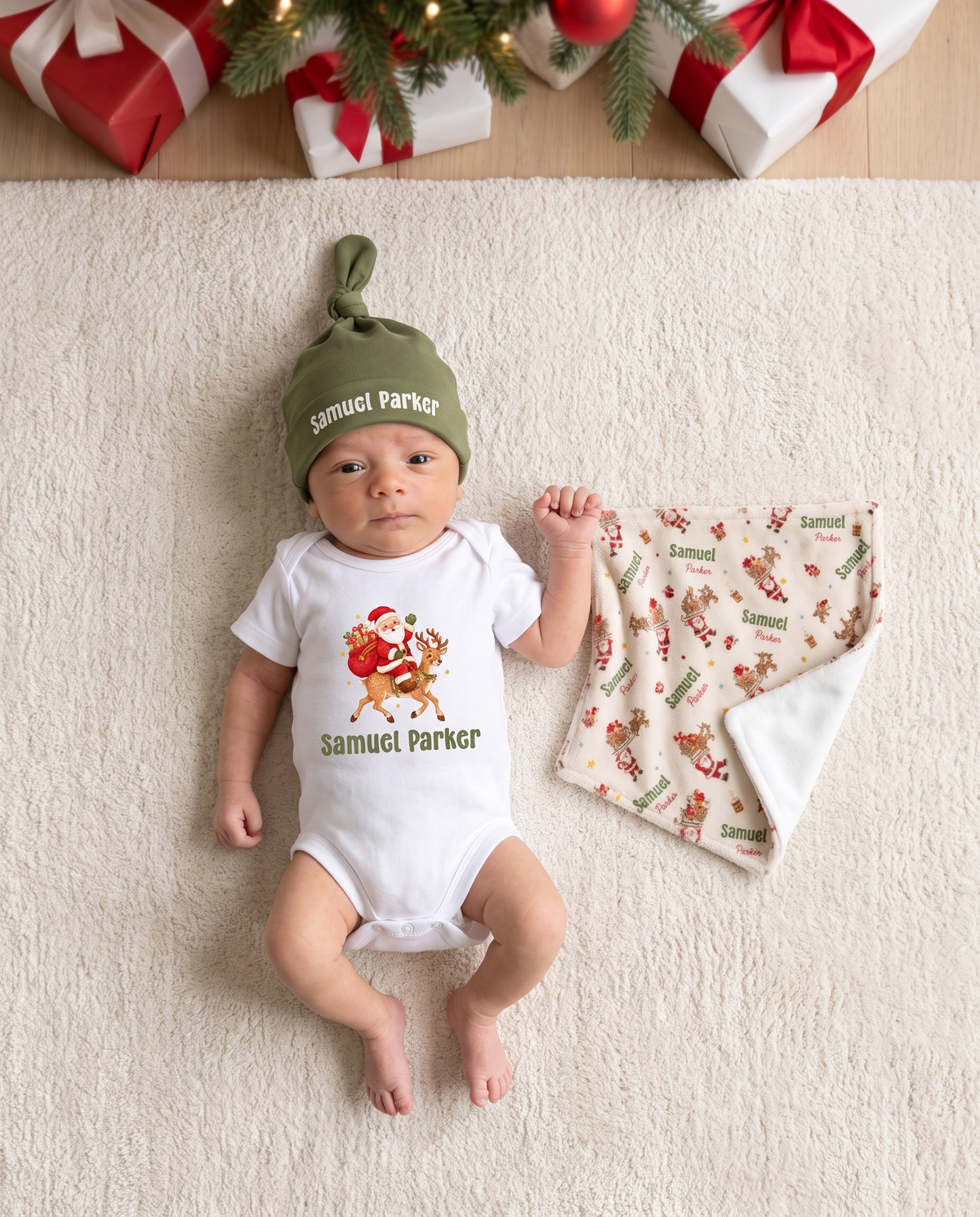 Newborn in a knotted hat lying on a rug next to the Santa's Joyride mini lovey