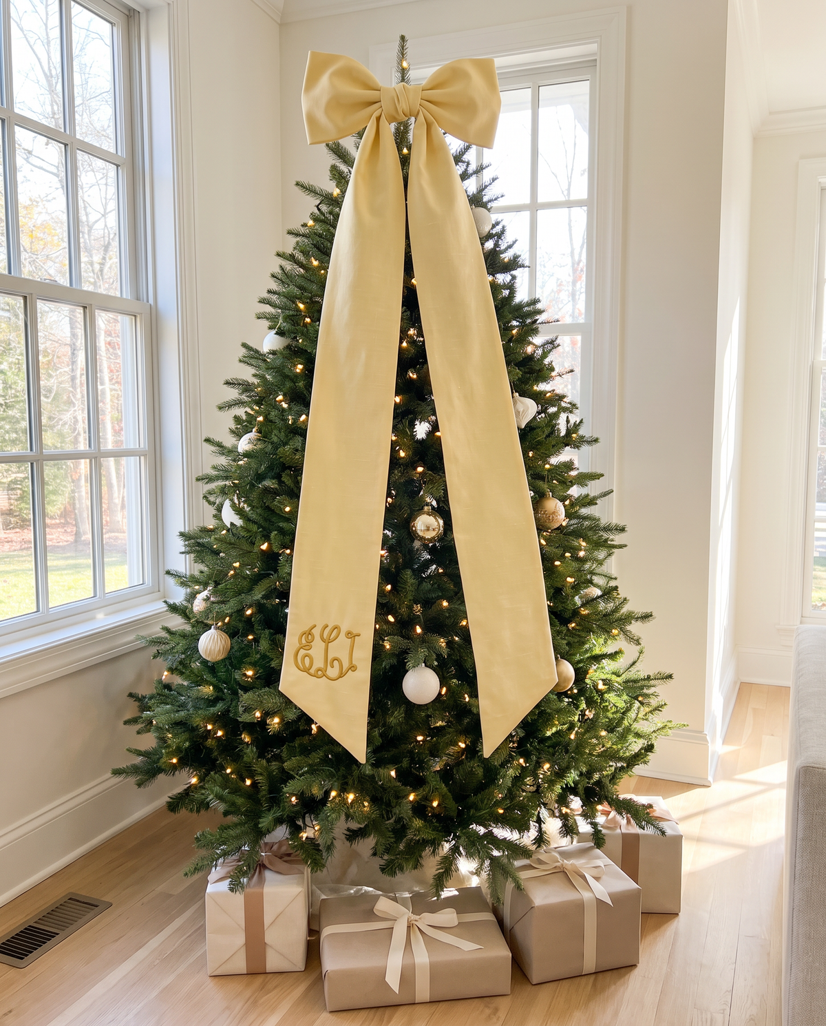 Light yellow bow sash tied to the top of a Christmas tree