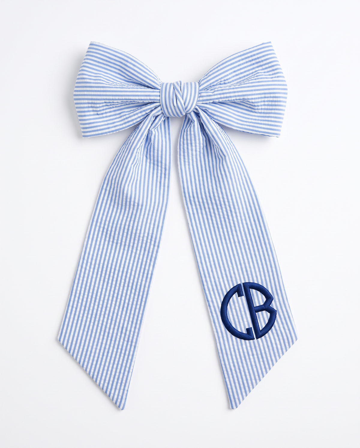 Striped blue bamboo seersucker bow sash tied in a bow with embroidered monogram