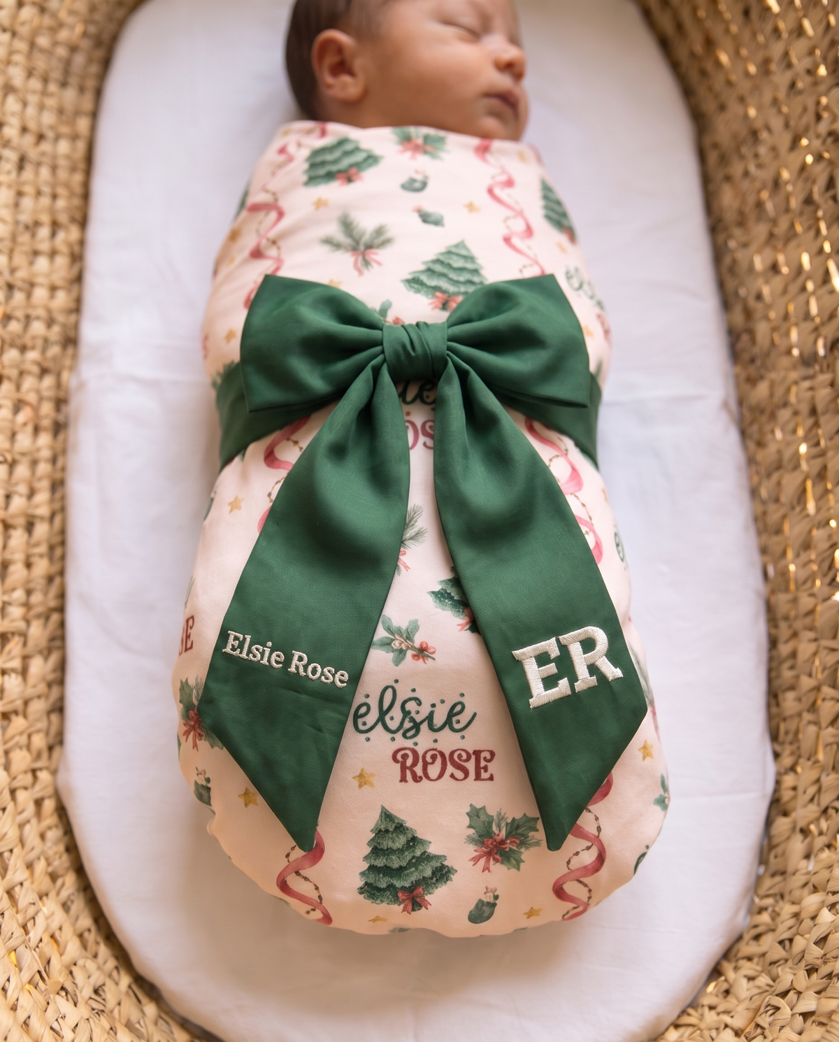 Close view of the forest green bow sash and white monogram on a swaddled baby
