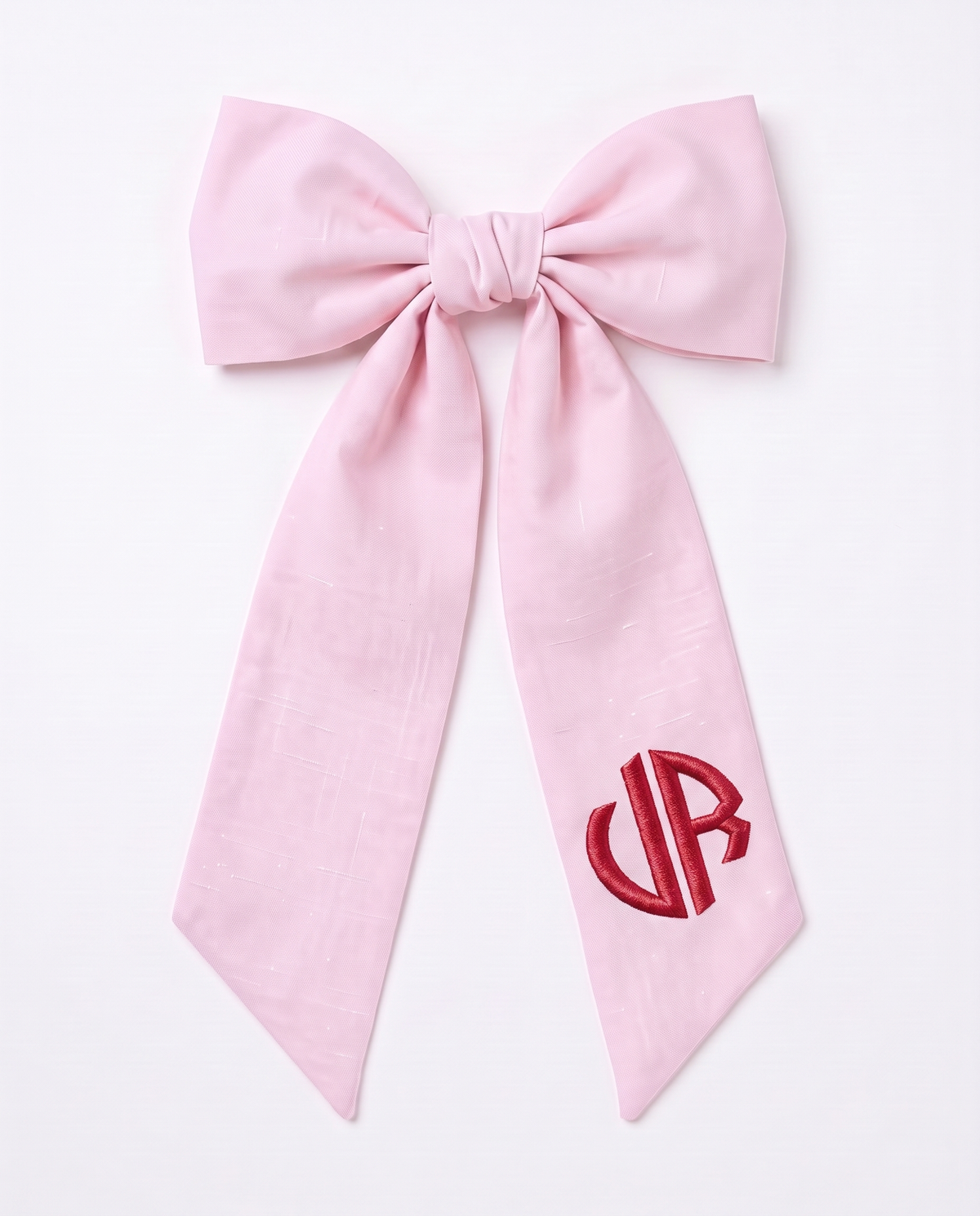Light pink linen-cotton newborn bow sash with red monogram embroidery, on white