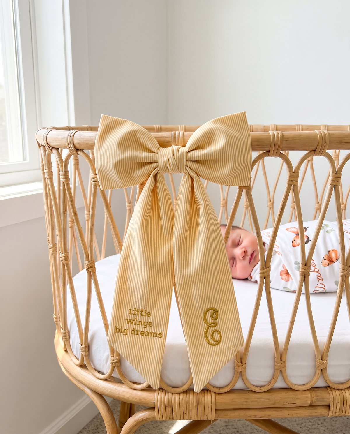 Striped yellow bow sash tied on a rattan bassinet
