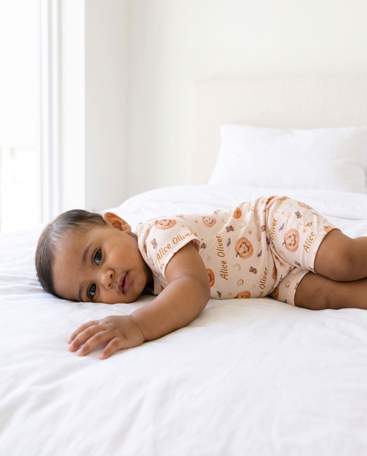 Side view of baby lying awake in the Golden Jack short-sleeve snap romper
