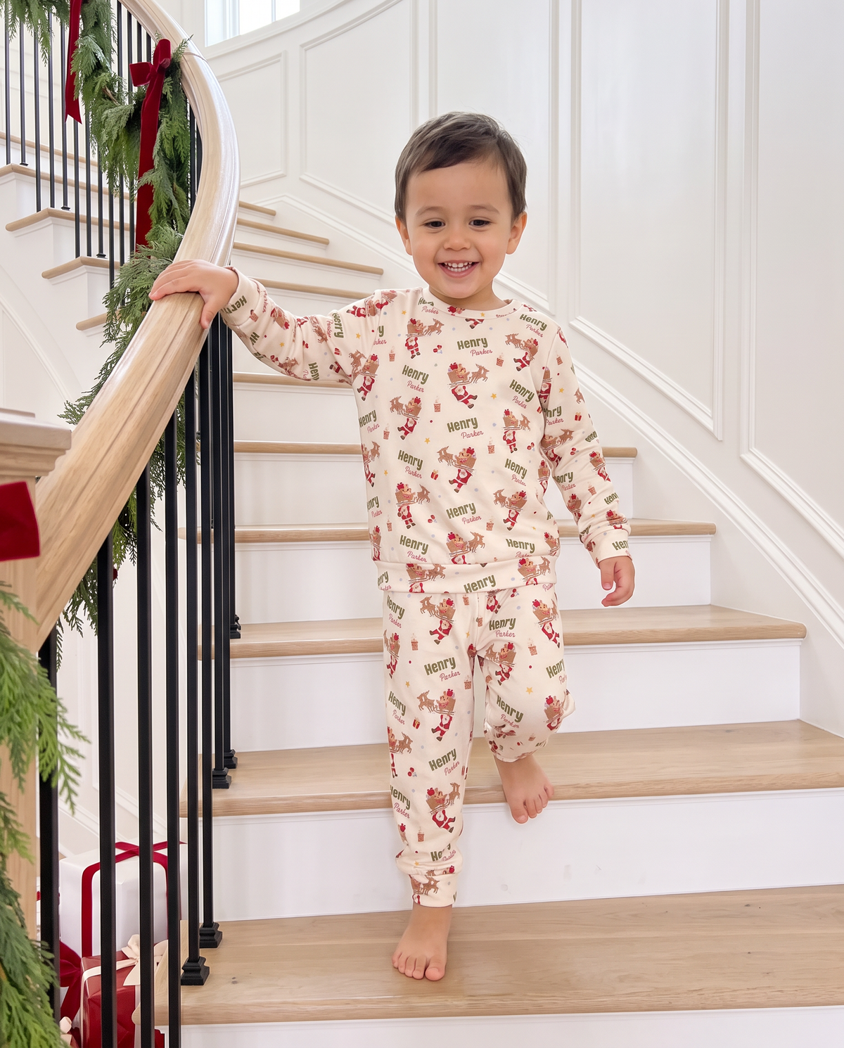 Toddler in the personalized Santa's Joyride two piece pajama set walking down the stairs