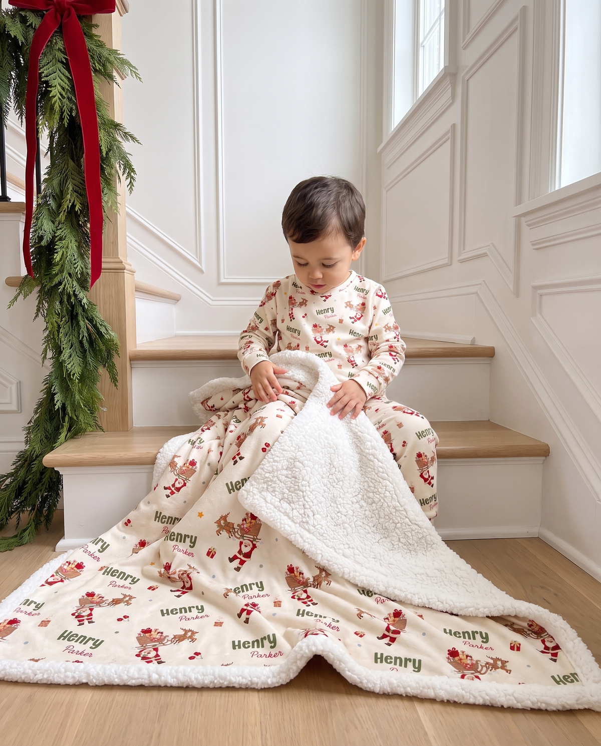 Little boy sitting on the stairs wrapped in the personalized Santa's Joyride sherpa blanket