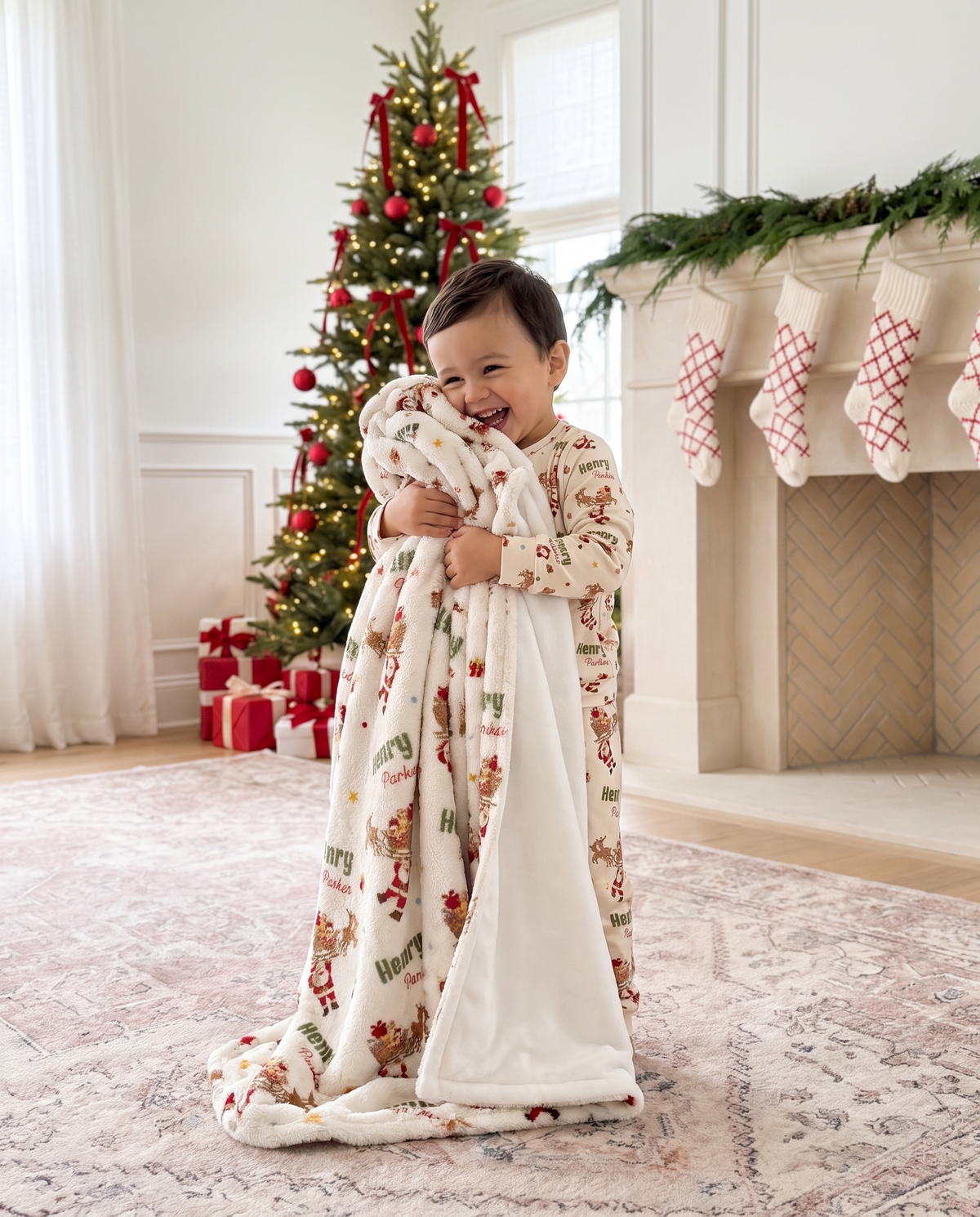 Toddler hugging the Santa's Joyride blanket in front of the Christmas tree and fireplace