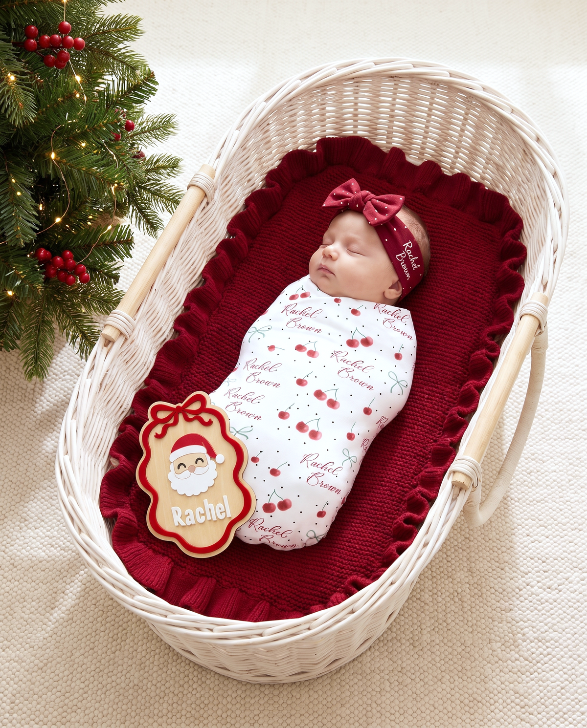 Ribbon Santa wood announcement sign at the foot of a bassinet beside a Christmas tree