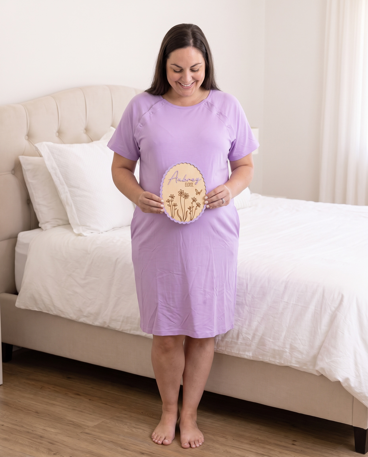 Expecting mother in a lavender gown holding the Scalloped Bloom wood announcement sign