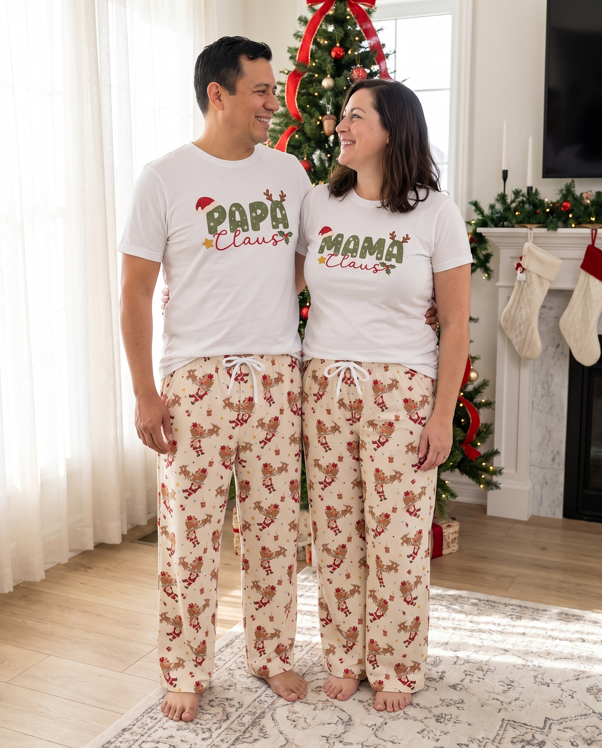 Couple in Mama and Papa Claus tees and Santa's Joyride pants by the tree